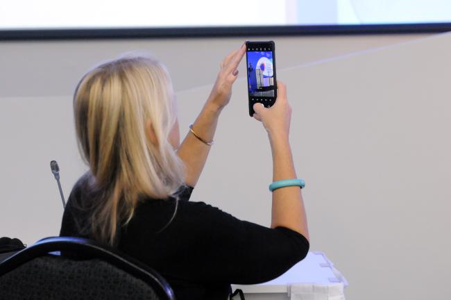 A participant takes a photo of Gurbuz Gonul, International Renewable Energy Agency (IRENA)