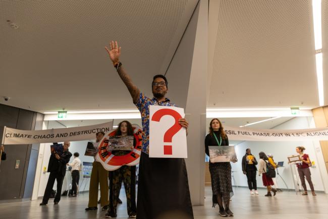 In an interactive action by civil society, delegates are asked whether they want to chose the path to a fossil fuel phase out, or climate chaos and destruction
