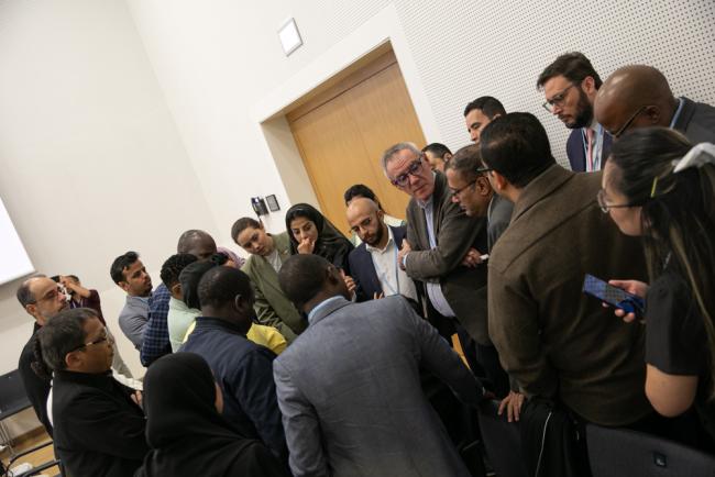 Delegates huddle during the informal consultations on response measures