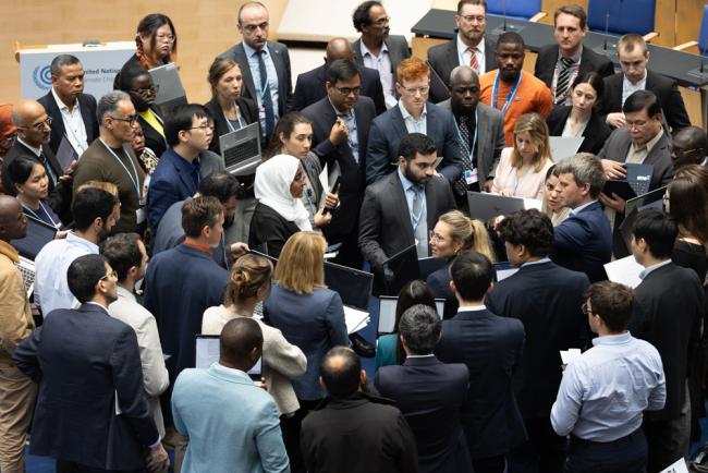 As the June Climate Conference enters its final days, delegates huddle during consultations on Article 6.8 to find a way forward