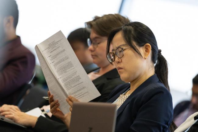 Delegates review the co-facilitators note during the informal consultations on the Warsaw International Mechanism (WIM)