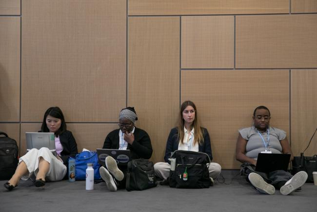 Delegates sit on the floor during the consultation on NAPs as the room is filled to capacity