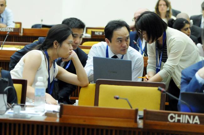 Chinese delegates confer during the session