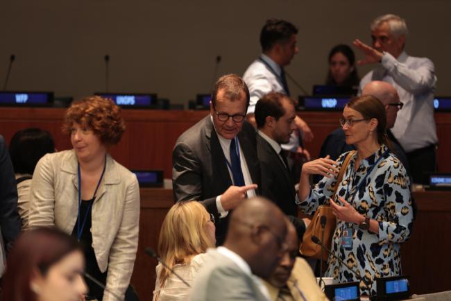 Delegates speak informally between sessions