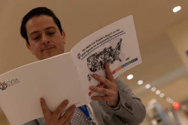 A delegates reads the US People's Report on the 2030 Agenda
