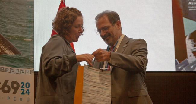 IWC Scientific Committee Chair Alex Zerbini, Brazil, gave a gift to Kate Wilson as a token of appreciation for her work - IWC69-26sep2024