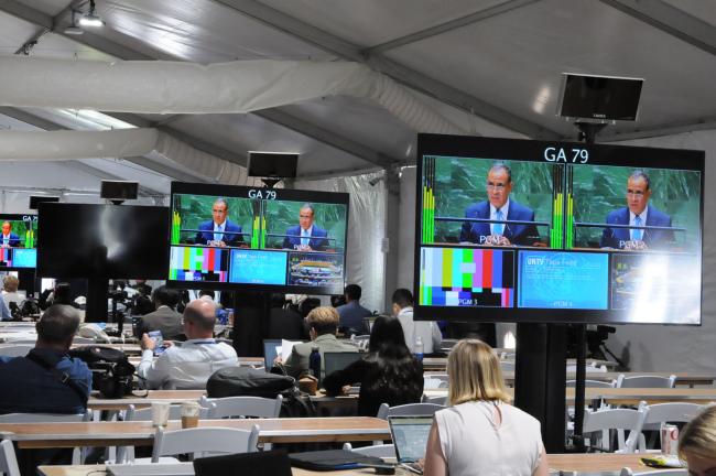 Journalists follow the proceedings from the media room