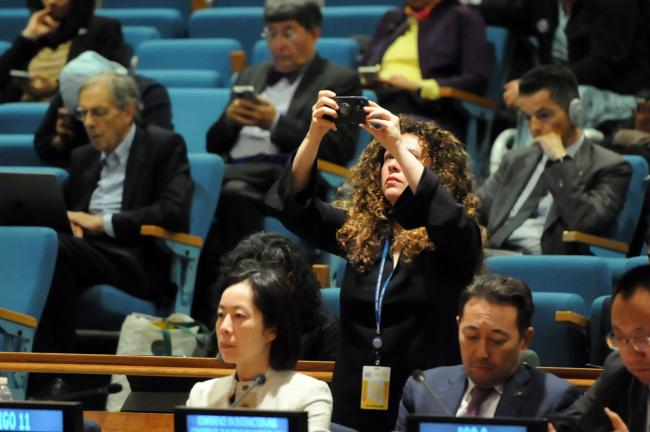 A participant takes a photo of the dialogue speakers