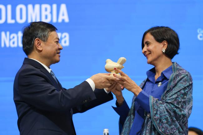 COP 16 President Susana Muhamad, Colombia, donating to COP 15 President Huang Runqiu, China a replica of Fernando Botero’s symbol of the peace process in Colombia, made with wheat by artisans from Nariño, Colombia as a recognition of his efforts for biodiversity conservation