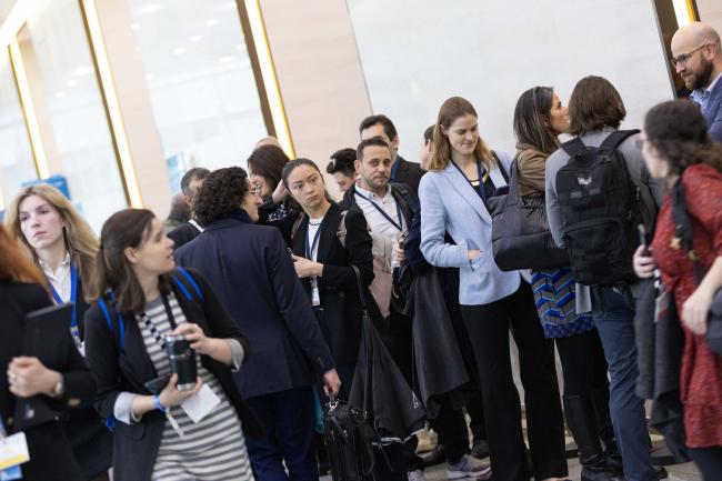 Observer delegates queue outside the contact group rooms as they are filled to capacity
