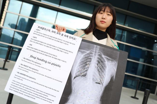 On the fourth day of INC-5, a member of civil society stands outside the venue, drawing attention to the harmful impacts of plastics to human health