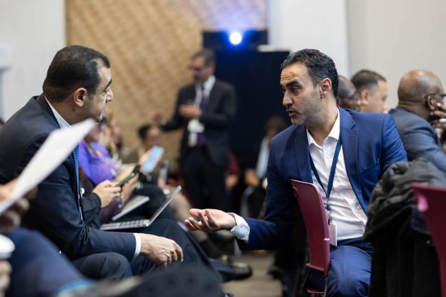 Yaser Khalil Abu Shanab, State of Palestine (right), speaks with a delegate