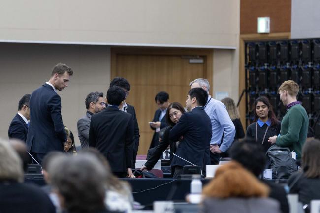 Delegates speak informally during discussions in Contact Group 1