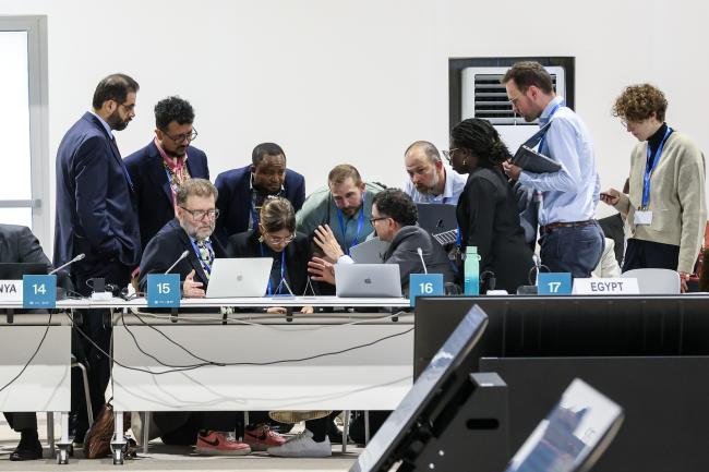 Delegates in a huddle during a contact group on finance