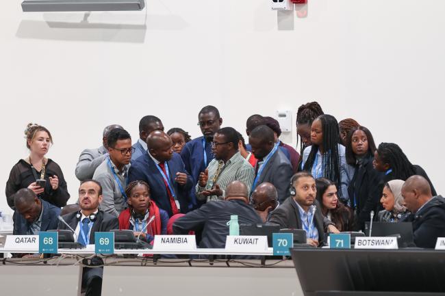 Delegates in a huddle during a contact group on Loss and Damage