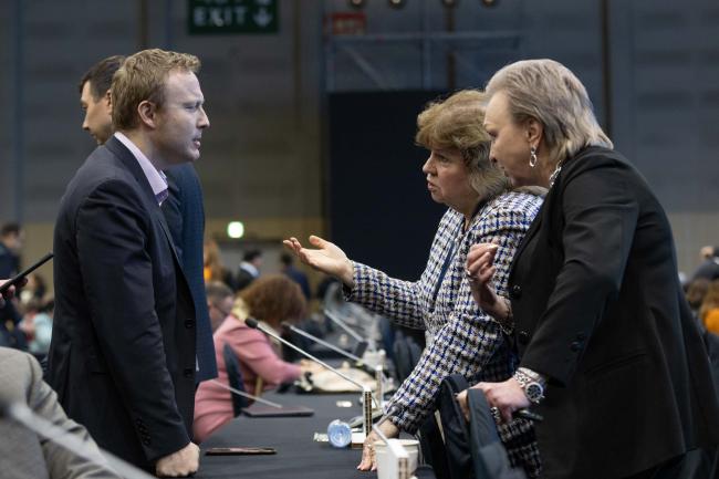 Delegates consult informally before the start of plenary