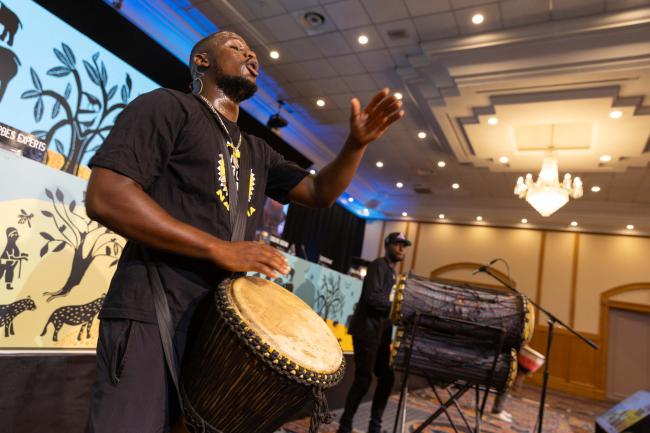 Delegates participate in an interactive drumming session