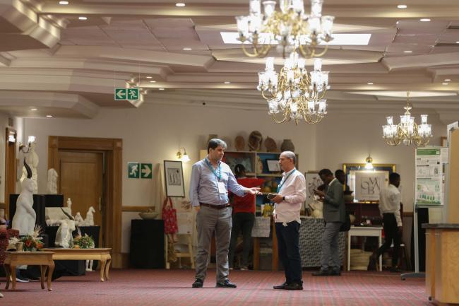 Delegates speak informally between sessions