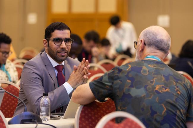 Mohammed Alshamlan, Saudi Arabia, speaks with a delegate