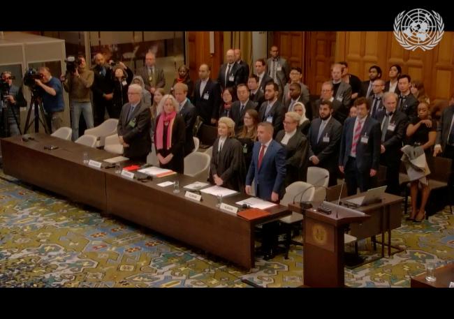 Participants stand while the ICJ judges enter into the room.