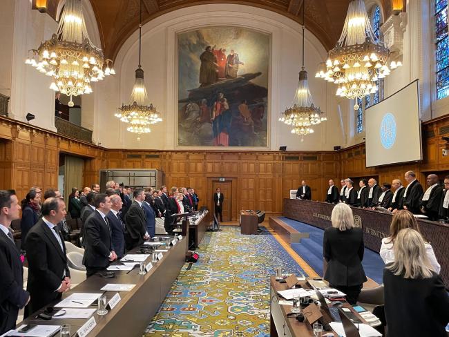 Participants stand at the beginning of Wednesday's proceedings