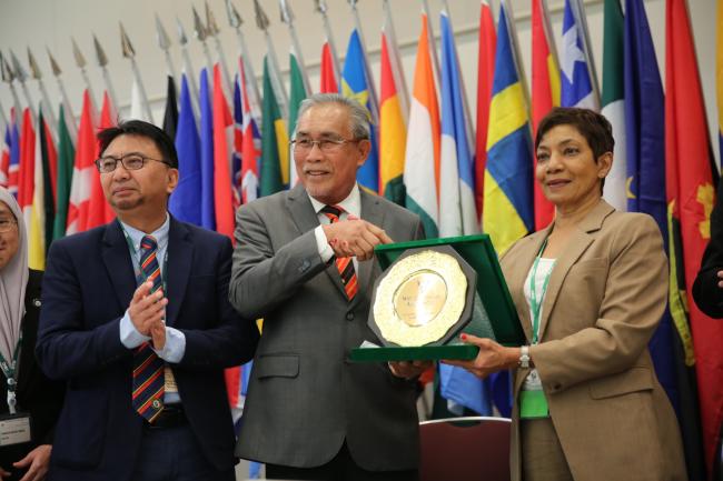 Sheam Satkuru, ITTO Executive Director, receives a plaque of appreciation from Haji Len Talif Salleh, Deputy Minister for Urban Planning, Land Administration and Environment, Malaysia