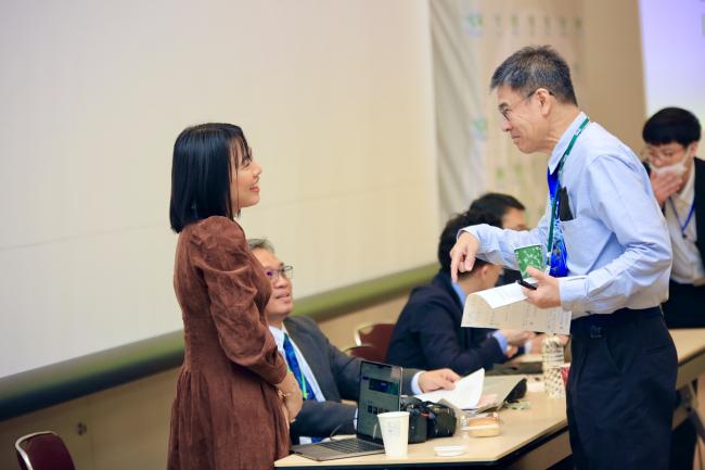 Two participants engage in an informal conversation during the ITTC60 session, fostering dialogue and collaboration.