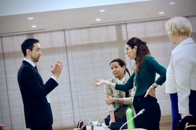 Simon Kawaguchi from the ITTO Secretariat engages in a discussion with Nora Ricken and other EU delegates during the session.