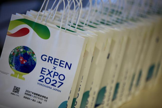 Promotional bags for the GREEN x EXPO 2027 in Yokohama, Japan, lined up for distribution.
