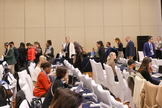 Delegates leave the room to continue the deliberations in a huddle. 