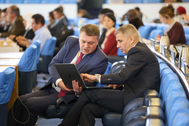 Delegates from the Russian Federation conferring during plenary