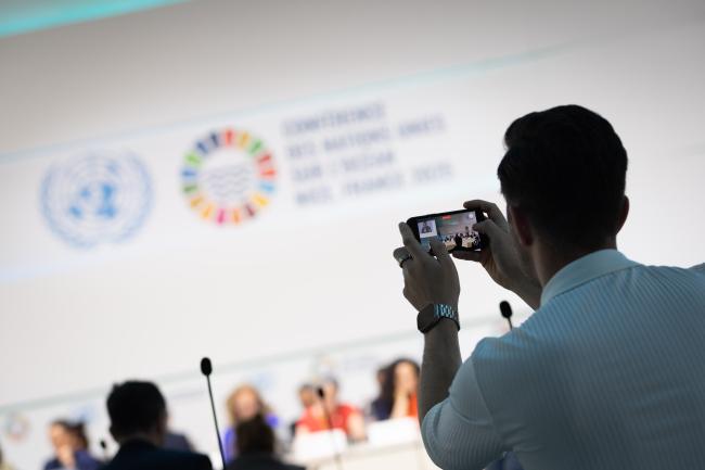 A delegate takes photos during an Ocean Action panel