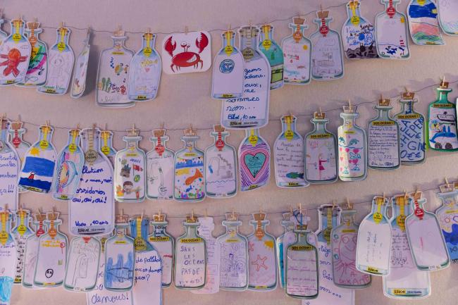 Around the green zone, people send messages in a bottle to convey the urgency of protecting the Ocean