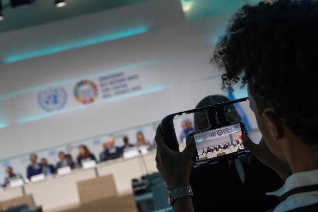 A delegate takes a photo of the panel speakers for Ocean Action Panel 8