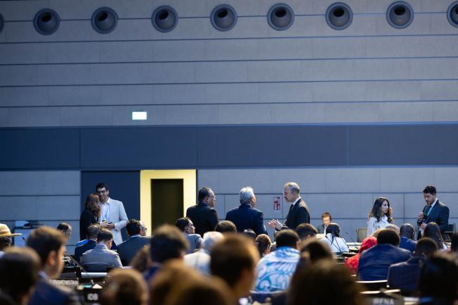 Delegates wait as the start of plenary is delayed