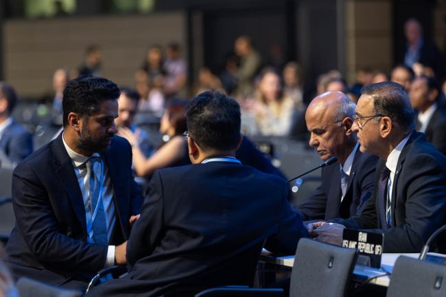 Delegates from Saudi Arabia, China, and Iraq consult