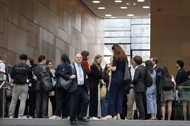 Delegates wait outside the meeting rooms for different sessions to begin