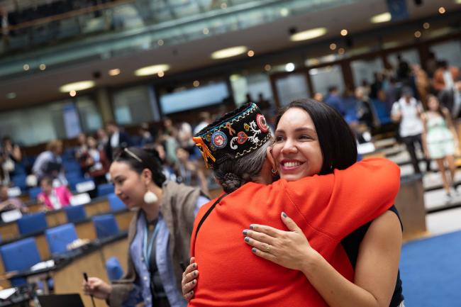 Delegates share a greeting between sessions