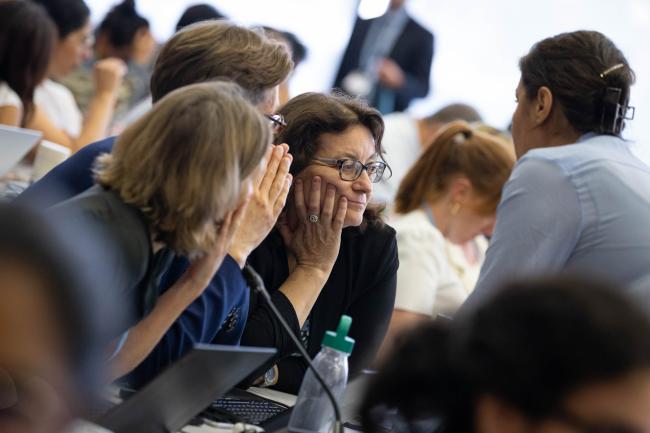 Delegates consult during discussions on the GGA
