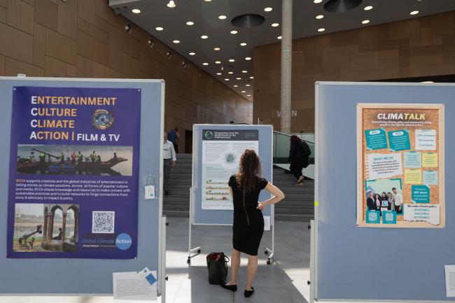Delegates read the posters on display in the lobby to learn more about climate action taking place around the world
