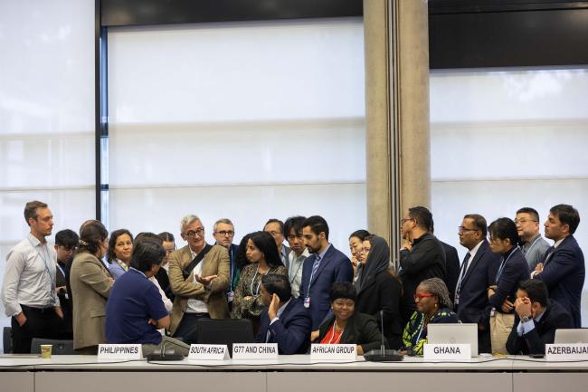 Delegates huddle during informal consultations on response measures