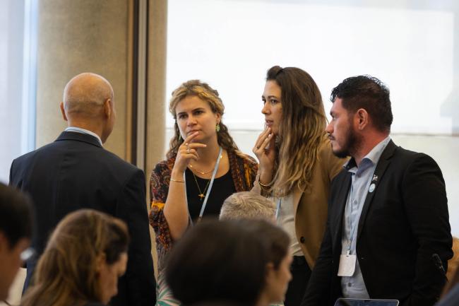 Delegates consult informally during discussions on the GGA
