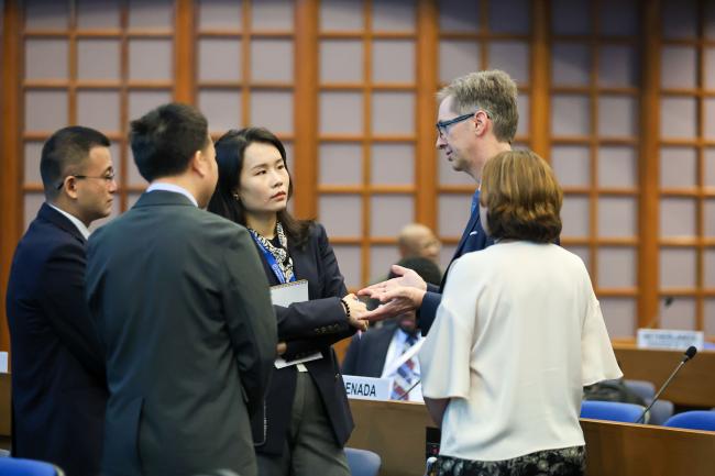 Delegates from China and the United States consult before the session starts. 