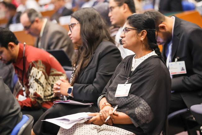Delegates follow the proceedings.