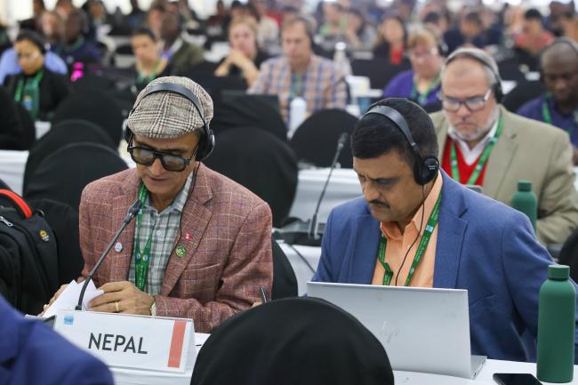 Delegates from Nepal review the discussed documents.