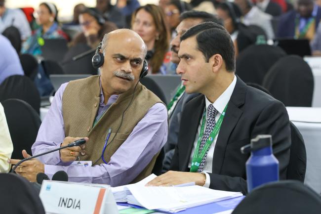 Delegates from India consult during the session. 