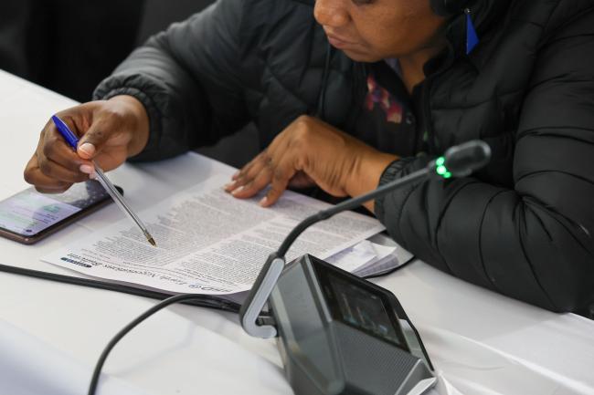 A delegate reads the Earth Negotiations Bulletin's report 