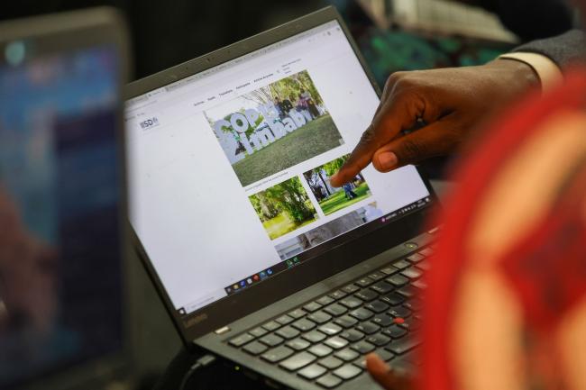 Delegates look at their pictures on Earth Negotiations Bulletin's webpage