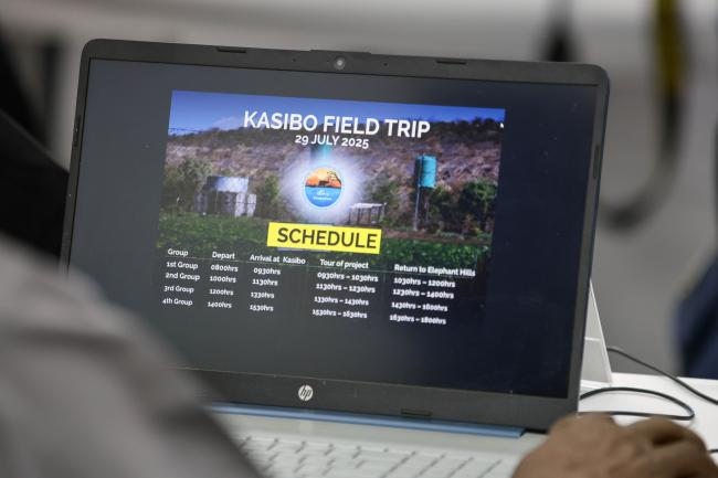 Delegates check the schedule of the field trip.