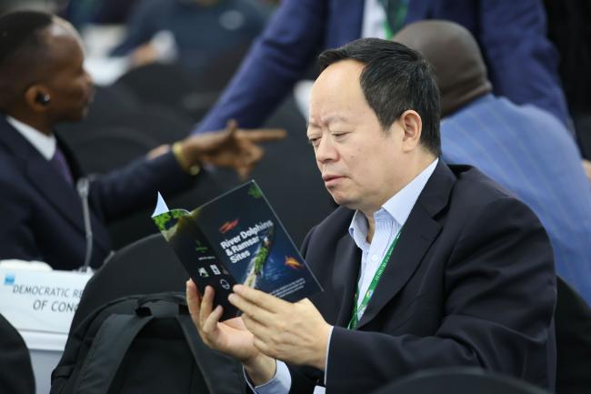 A delegate reads a brochure on river dolphins